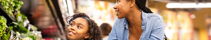 A mother and daughter shopping through Food City, earning points for their school during school bucks.